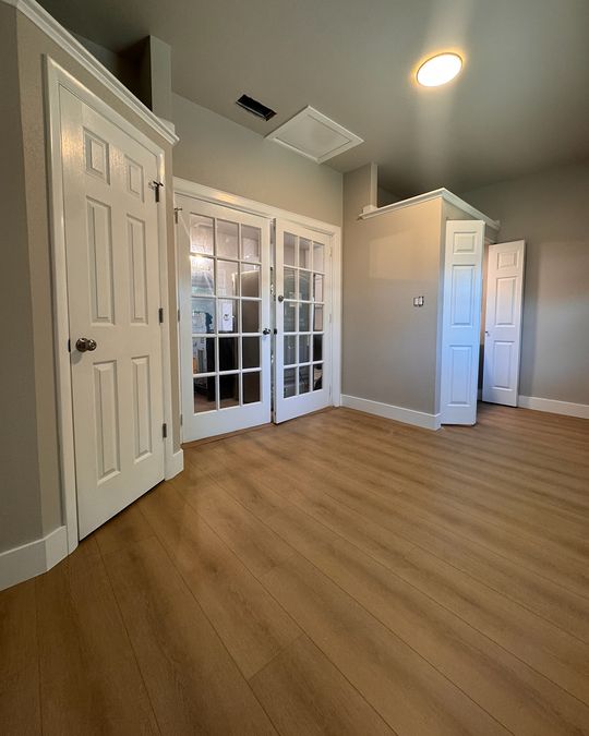 A study with a glass-paneled entry and a new wood-look plank floor.